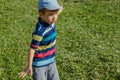 Young boy runs in a green field. Cute child running across park outdoors grass. Royalty Free Stock Photo