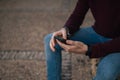 A young boy`s hands using his mobile phone on the street Royalty Free Stock Photo