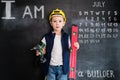 Young boy`s standing with screwdriver near blackboard. Young builder. Creative design concept for 2019 calendar. July