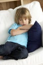 Young Boy Sat on Sofa at Home Royalty Free Stock Photo