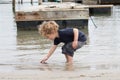 Young Boy Searching for Shells in Harbor Royalty Free Stock Photo