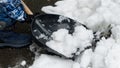 Young boy is shoveling snow from the backyard or walkway with a shovel after a snowstorm or blizzard. Child's effort and