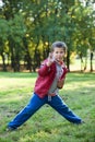 Young boy showing karate techniques in autumn park