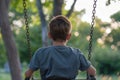 A young boy sits on a swing in a park, lost in thought, A boy sitting alone on a swing, lost in thought