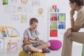 Young boy sits on a yellow pouf