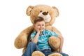 Young boy sitting at a big teddy bear