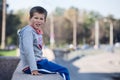 Young boy sitting on edge of the granite curb, copyspace Royalty Free Stock Photo
