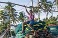 Young boy sitting on the fishing nets in the boat