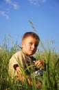 Young boy sitting on green grass Royalty Free Stock Photo