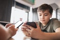 Young boy sitting with parent using mobile phone,Man hand holding smart phone ordering food in restaurant,Kid playing game or Royalty Free Stock Photo