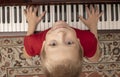 Young pianist playing at the piano at home. Boy looking at camera Royalty Free Stock Photo