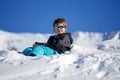 Young Boy Sitting On The Snow Mountain Royalty Free Stock Photo