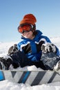 Young Boy Sitting In Snow With Snowboard Royalty Free Stock Photo