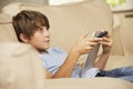 Young Boy Sitting On Sofa At Home Using Tablet Computer Whilst Watching Television Royalty Free Stock Photo