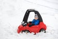 Young Boy Sitting in a Toy Car Stuck in the Snow Royalty Free Stock Photo