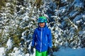 Young boy in ski helmet and mask stand over snow covered firs Royalty Free Stock Photo