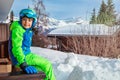 Young boy in ski outfit sit on balcony rail at winter vacations Royalty Free Stock Photo