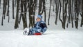 Young boy sledging down a snowy hill with excitement and exhilaration. The perfect scene to showcase the fun and joy of winter