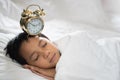 Young boy sleeping with alarm clock Royalty Free Stock Photo