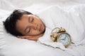 Young boy sleeping with alarm clock Royalty Free Stock Photo