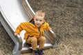 Young Boy Sliding Down the Slide in Playground Royalty Free Stock Photo