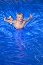 Young boy sliding down a slip and slide outdoors Royalty Free Stock Photo