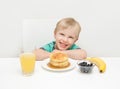 A young boy smiling with his breakfast of pancakes, berries, ban Royalty Free Stock Photo