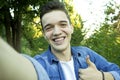 Young boy smiling at the park is taking selfie. Royalty Free Stock Photo