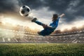 Young boy with soccer ball doing flying kick at stadium