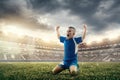 Young boy with soccer ball doing flying kick at stadium Royalty Free Stock Photo