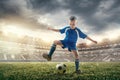 Young boy with soccer ball doing flying kick at stadium Royalty Free Stock Photo