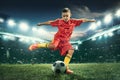 Young boy with soccer ball doing flying kick at stadium Royalty Free Stock Photo