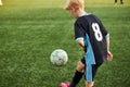 Young boy with soccer ball is in motion on green grass background Royalty Free Stock Photo