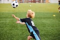 Young boy with soccer ball is in motion on green grass background Royalty Free Stock Photo