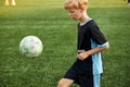 Young boy with soccer ball is in motion on green grass background Royalty Free Stock Photo
