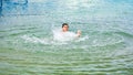 Young boy spalshing and having fun at the beach during a summer vacation Royalty Free Stock Photo