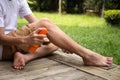 Young boy spraying insect repellents on his leg with spray bott