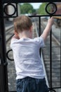 Young boy standing at back of train looking down at track Royalty Free Stock Photo