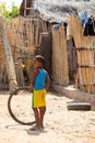 Young boy standing on a dirt road holding a tire Miandrivazo, Madagascar