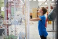 Young boy standing looking at a science exhibit, side view Royalty Free Stock Photo