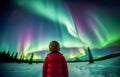 Young boy standing looking at spectacular northern lights aurora borealis. Royalty Free Stock Photo