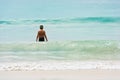 A young boy stands at the ocean shore