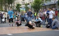 Young boy, street dancer, performimg break dance on the pavement, teenagers watching beside Royalty Free Stock Photo