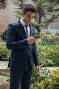 Young boy with suit and tie using black mobile phone Royalty Free Stock Photo