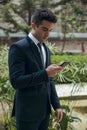 Young boy with suit and tie using black mobile phone Royalty Free Stock Photo