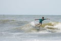 A young boy surfs waves on the Atlantic Ocean