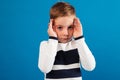 Young boy in sweater holding his hands near the eyes Royalty Free Stock Photo