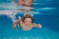 Young boy swim and dive underwater. Under water portrait in swim pool. Child boy diving into a swimming pool. Cute boy Royalty Free Stock Photo