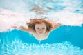 Young boy swim and dive underwater. Under water portrait in swim pool. Child boy diving into a swimming pool. Kids swim Royalty Free Stock Photo