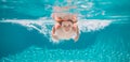 Young boy swim and dive underwater. Under water portrait in swim pool. Child boy diving into a swimming pool. Summer Royalty Free Stock Photo